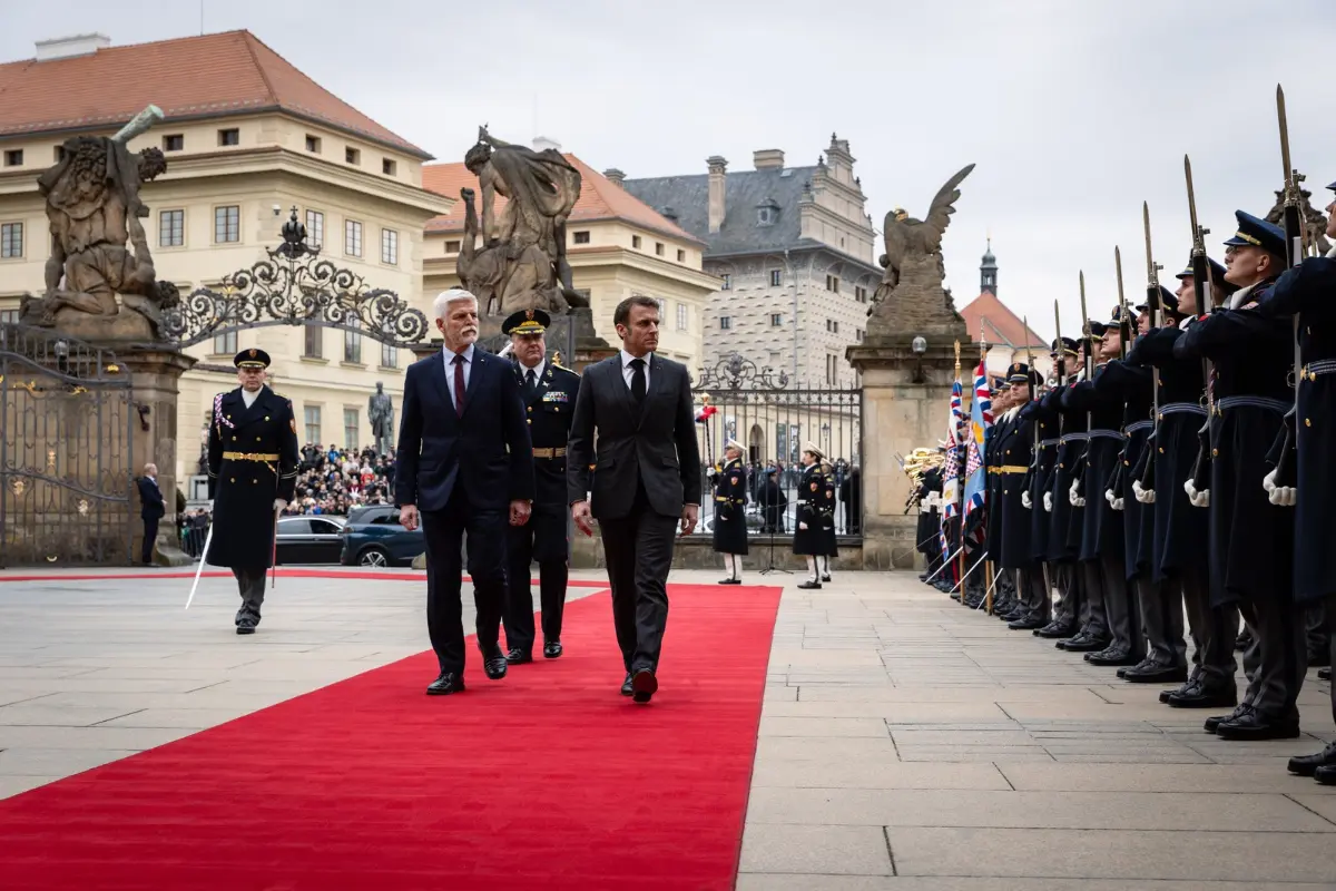 Ceremoniál na červeném koberci s účastí prezidentů České republiky a Francie před bránou Pražského hradu, v pozadí s vojenskou stráží