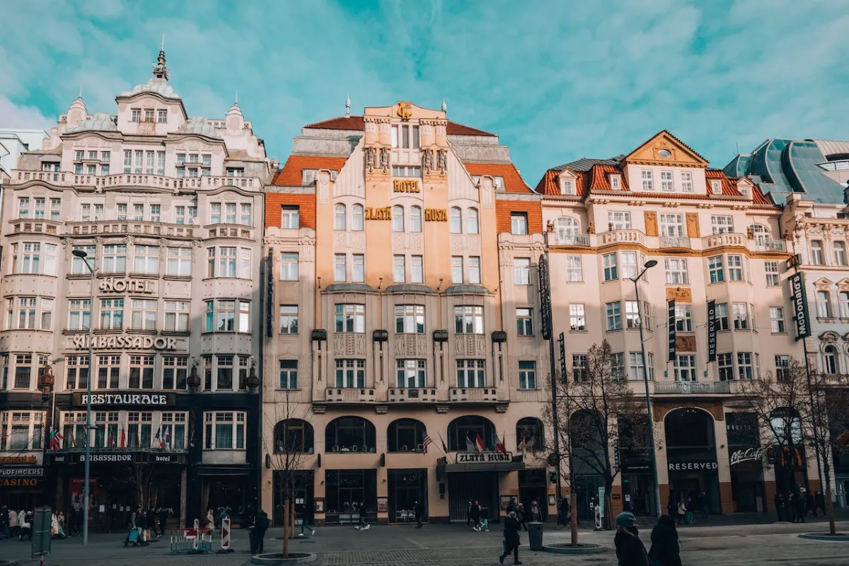 Pedestrians passing by The Golden Goose Hotel and Hotel Ambassador in vibrant Wenceslas Square