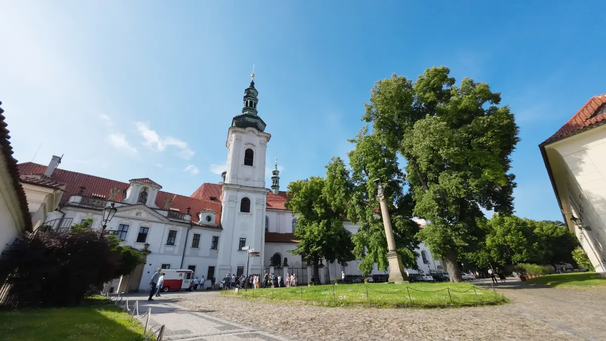 Summer day at Strahov Monastery, Prague, embraced by lush green trees under the sun