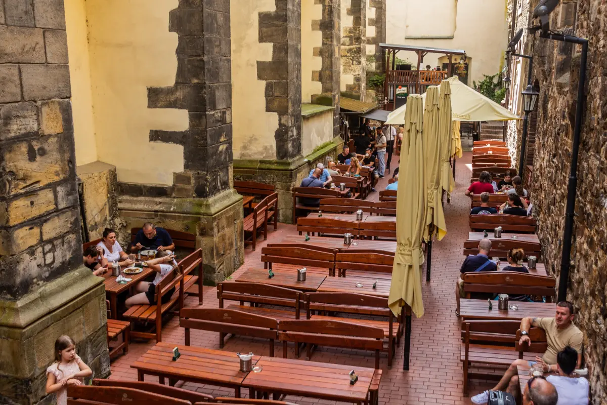 People enjoying outdoor seating at U Pinkasu pub in Prague